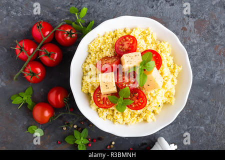 Millet Porridge mit Tomaten und Käse Stockfoto