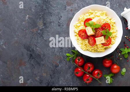 Millet Porridge mit Tomaten und Käse Stockfoto