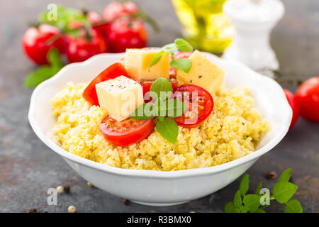 Millet Porridge mit Tomaten und Käse Stockfoto