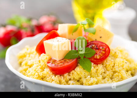 Millet Porridge mit Tomaten und Käse Stockfoto