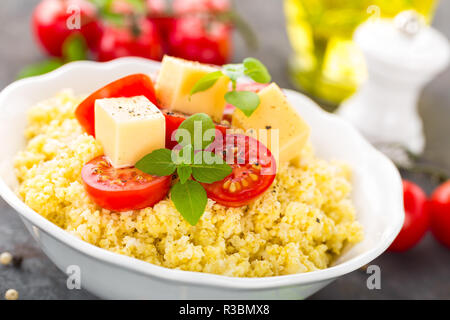 Millet Porridge mit Tomaten und Käse Stockfoto