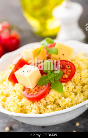 Millet Porridge mit Tomaten und Käse Stockfoto