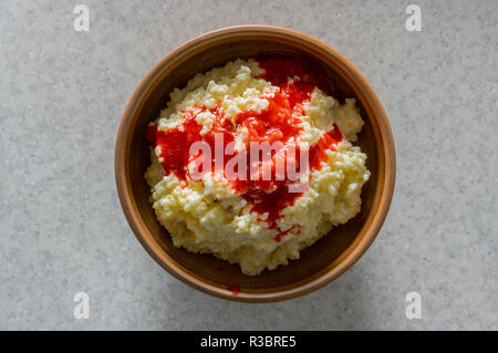 Ansicht von oben auf einen Teller mit Hirse Haferflocken in Milch mit sultana gekocht, Quitte Stücke und mit frischen Himbeersaft aromatisiert Stockfoto