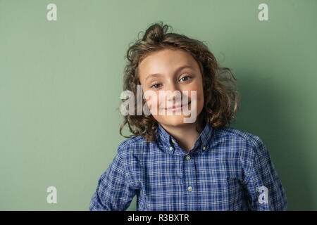 Süße kleine Jungen mit langen Locken selbstbewusst lächelnd Stockfoto