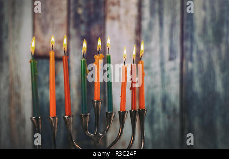 Menorah mit bunten Kerzen für Chanukka auf Licht, Nahaufnahme Stockfoto