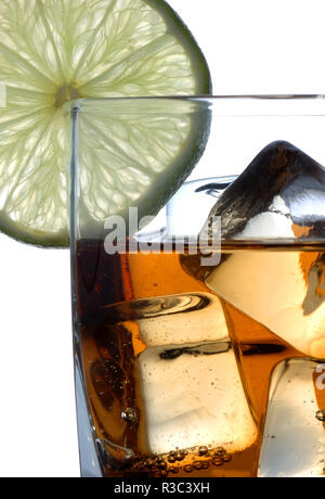 Trinken mit Slice von Kalk. Nahaufnahme auf Eiswürfel eingetaucht in Whiskey. Isoliert weißer Hintergrund. Stockfoto