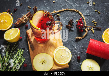 Weihnachten Glühwein mit Gewürzen und Orangenscheiben auf Tisch aus Stein. Traditionelle Getränk auf Winterurlaub. Stockfoto