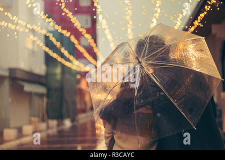 Verliebtes Paar auf der Straße an einem regnerischen Tag. Freunde auf der Straße Stockfoto