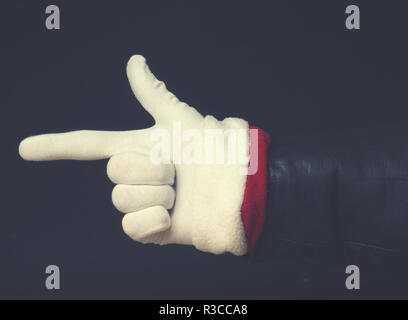 Arm von Santa mit Lederjacke auf einem dunklen Hintergrund, moderne Wohnung Ton stilisierte Weihnachten Konzept Stockfoto
