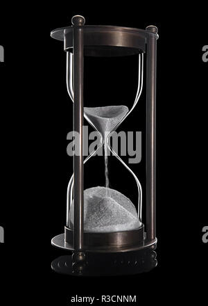 Elegante und stilvolle Bronze vintage rieselnde Sanduhr mit weißem Sand. Objekt wird mit der Reflexion auf schwarzem Hintergrund isoliert. Für Zeit betätigt, Stockfoto