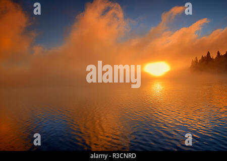 Kanada, Manitoba, Whiteshell Provincial Park. Nebliger Sonnenaufgang am Caddy See. Stockfoto