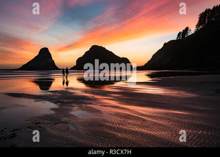 Zwei Personen Silhouette bei Sonnenuntergang mit Seastack und Strand bei Sonnenuntergang, von Devil's Elbow State Park, Illinois Stockfoto