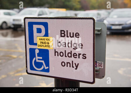 Zeichen erinnern behinderte Treiber für einen Parkplatz zu zahlen. Stockfoto