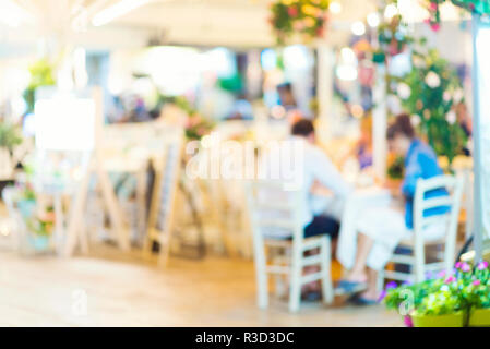 Unscharfer Hintergrund der Szene in einem Restaurant, verschwommenes unkenntlich Leute am Tisch sitzen im Garten Stockfoto