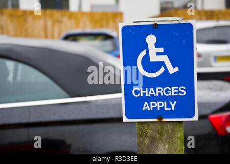 Zeichen erinnern behinderte Treiber für einen Parkplatz zu zahlen. Stockfoto