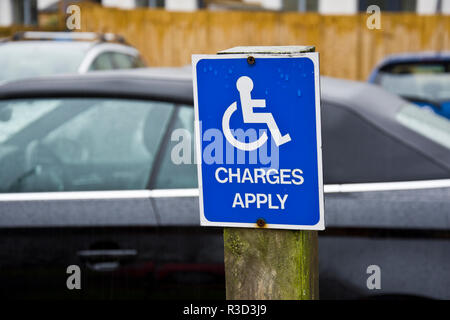 Zeichen erinnern behinderte Treiber für einen Parkplatz zu zahlen. Stockfoto