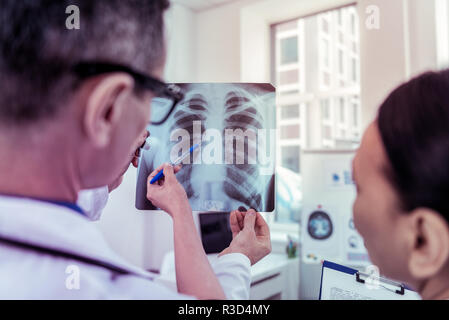 Etwas seltsam. Schwere Arzt X Holding-ray Bild, Hören auf sein Kollege Stockfoto