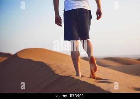 Junge Mann zu Fuß auf der Sanddüne. Wahiba Sands in Oman. Stockfoto