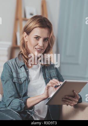 Professionelle Freelancer. Angenehme nette Frau zu Ihnen schauen, während die von zu Hause aus arbeiten Stockfoto