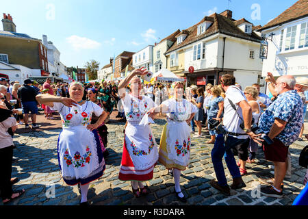 Faversham Hop Festival, Parade. Balaton Frauen ungarische Tänzer, marschieren und Tanzen durch überfüllte Straße mit Zuschauer. Stockfoto