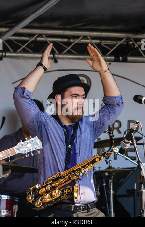 Faversham Hop Festival 2018, vintage Swingtime band Gänsehaut auf der Bühne. Mann, Nick Brown, Saxophonist mit Hemd und Krawatte, Klatschen mit erhobener Hand Stockfoto