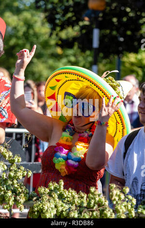 Faversham Hop Festival 2018. Reife Frau im Publikum tragen Aufblasbare gelb Mexikanischen sombrero, und über große Sonnenbrillen, Mitsingen. Stockfoto