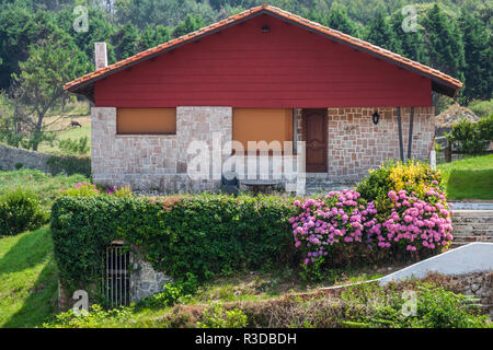 Ein neues Haus mit Garten in einem ländlichen Gebiet unter dem schönen Himmel Stockfoto