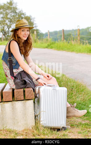 Mädchen mit Koffer warten auf den Abflug Stockfoto