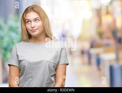 Junge kaukasier Frau über isolierte Hintergrund lächelnd Seite suchen und sie starrte Denken. Stockfoto