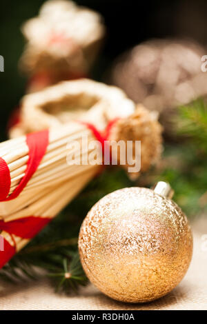 Goldene Weihnachtskugeln funkelnde auf Tannenzweigen mit Schnee Stockfoto