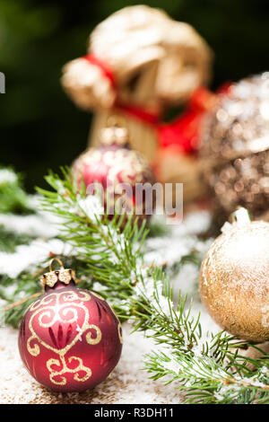 Goldene Kugeln auf pine Zweige mit glitzernden Schnee Stockfoto