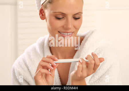 Frau Polituren Ihre Nägel Stockfoto