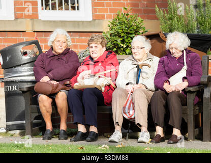 Vier ältere Frauen sitzt auf der Bank. Großbritannien Stockfoto