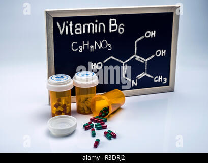 Vitamin B6 von Hand auf einer Tafel neben Flaschen von Kapseln, konzeptionelle Image geschrieben Stockfoto