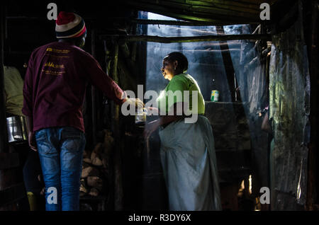 Eine Frauen gesehen in einer lokalen Bar der Verkauf von Alkohol in Kibera. Für eine lange Zeit, die meisten Frauen aus Kibera Slums haben unter dem Einfluss von Alkohol. Nicht angesichts der Nebenwirkungen, Frauen hier ist aus verschiedenen Gründen einschließlich der Übernahme von Stress und über ihre Probleme in der Familie zu Hause zu vergessen. Dies ist wegen des Mangels an genügend Beschäftigungsmöglichkeiten und Unterstützung von ihren Ehemännern der hohe Alkoholkonsum hat zu einer höheren Rate von Todesfällen, Blindheit geführt, und das Risiko für viele gefährliche Krankheiten wie Krebs, Bluthochdruck, Schlaganfall und traumatischen Verletzungen mit jungen Kindern hinter Links Stockfoto
