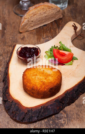 gebackener Camembert auf einem Holzbrett Stockfoto