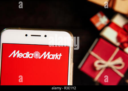 Deutsche Elektronikkonzern Handelskette Media Markt Logo auf einem Android mobiles Gerät mit Weihnachten gesehen wird eingepackte Geschenke im Hintergrund. Stockfoto