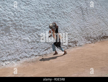 Harari Mädchen vor einer weißen Wand läuft, Harari Region, Harar, Äthiopien Stockfoto