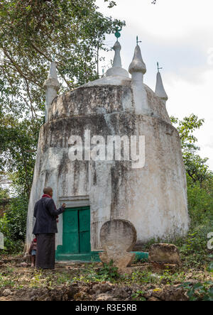 Harari Mann vor einem alten muslimischen Grab beten, Harari Region, Harar, Äthiopien Stockfoto