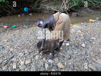 Suri Stamm Mädchen tun Goldwaschen in einem Fluß, Omo Valley, Kibish, Äthiopien Stockfoto