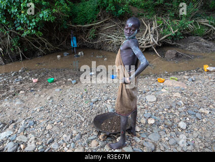 Suri Stamm Mädchen tun Goldwaschen in einem Fluß, Omo Valley, Kibish, Äthiopien Stockfoto