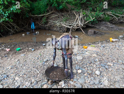 Suri Stamm Mädchen tun Goldwaschen in einem Fluß, Omo Valley, Kibish, Äthiopien Stockfoto