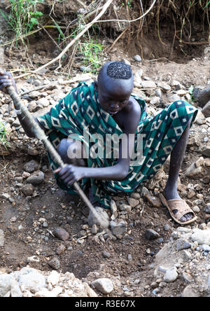 Suri Stamm Mädchen tun, Goldwaschen in einem Fluß, Omo Valley, Kibish, Äthiopien Stockfoto