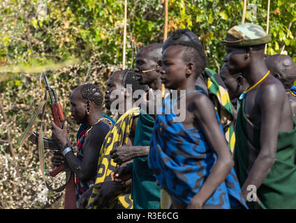 Suri Stamm Krieger paradieren vor einem donga Stockkampf Ritual, Omo Valley, Kibish, Äthiopien Stockfoto