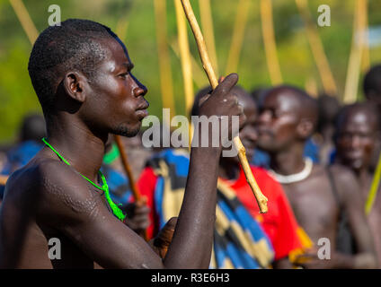 Suri Stamm Krieger paradieren vor einem donga Stockkampf Ritual, Omo Valley, Kibish, Äthiopien Stockfoto