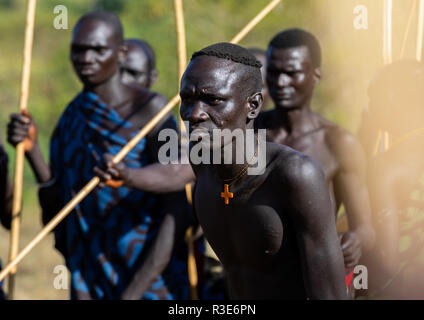 Suri Stamm Krieger paradieren vor einem donga Stockkampf Ritual, Omo Valley, Kibish, Äthiopien Stockfoto