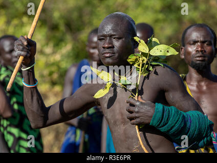 Suri Stamm Krieger paradieren vor einem donga Stockkampf Ritual, Omo Valley, Kibish, Äthiopien Stockfoto