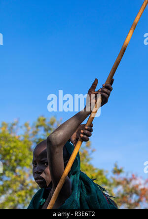 Suri Stamm Junge mit einem Stick während eines donga Ritual, Omo Valley, Kibish, Äthiopien Stockfoto