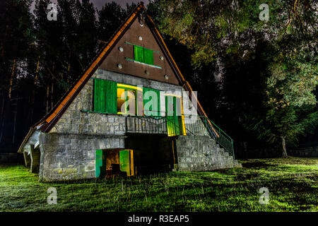 Lange Belichtung Foto von einem schönen Haus im Wald, mit Taschenlampen beleuchtet und realisiert mit der Technik des Lightwriting. Stockfoto