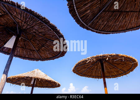 Strohgedeckten Sonnenschirm Schuß von unten über blauen Himmel. Mit Holz und Schilf Stockfoto